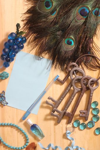 A Notepaper with copy space and Pen on Wooden Table Surrounded By Peacock Feathers and Jewelry