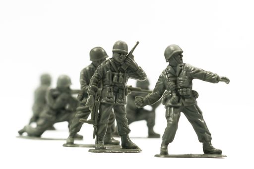 Toy soldiers are arranged in a conflict situation and isolated against a white background.