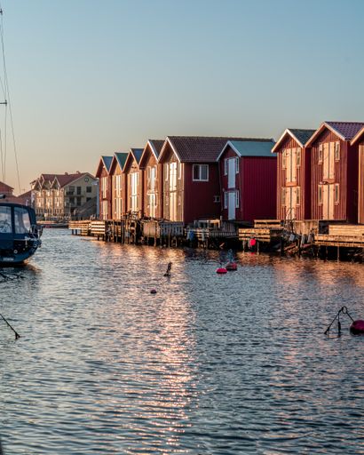 Portrait photo of a row of traditional red boathouses on the scenic island Smogen on the Swedish west coast