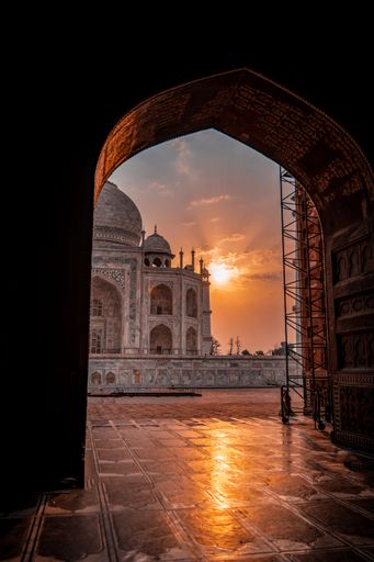 A vertical shot of a scenic view of the Taj Mahal Mausoleum at sunset through the archway of the mosque, Agra, India