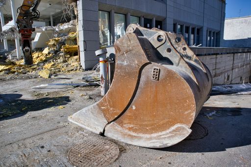 An excavator scoop at a demolition site on  aunny day outdoors