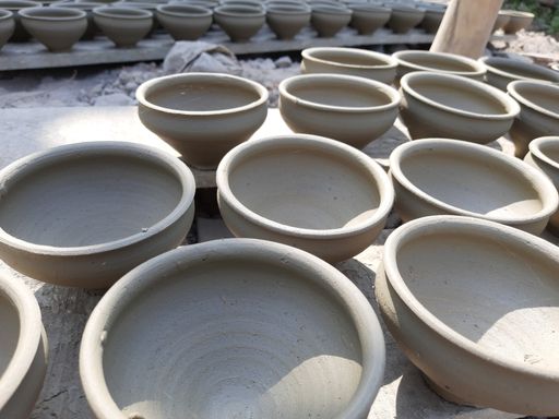 Clay pots are laying on the ground for drying in sunlight before going to fire