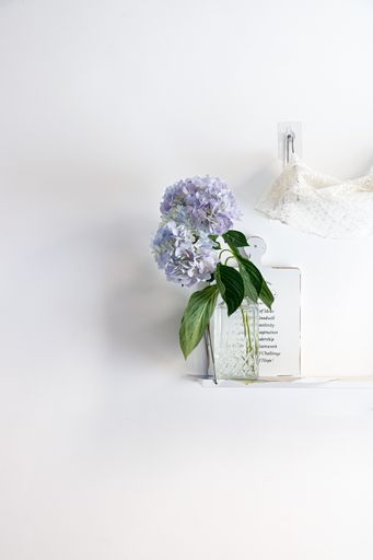 The vertical studio shot of still life composition with a vase with purple flowers