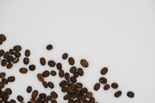 A high angle shot of coffee beans on a white surface