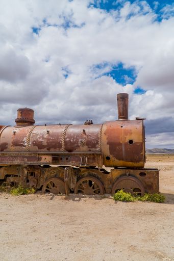 A vertical view of a rusty locomotive in the train cemetery in Uyuni, Bolivia
