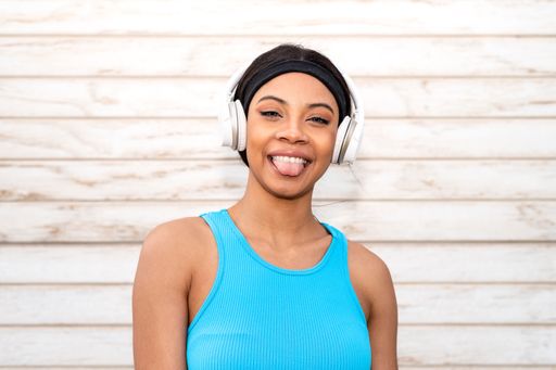 Portrait of a cheerful African American woman wearing sportswear and headphones.