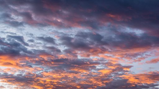 a low angle shot of the orange and blue sky during the sunset.