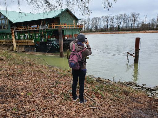 Back view of a photographer taking landscape photos of the Fraser River Vancouver Canada
