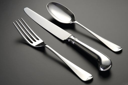 A closeup shot of silver utensils set isolated on a black surface