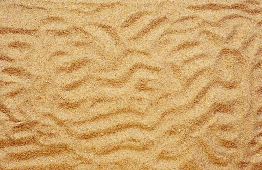 A high angle shot of patterns and textures on the sand-covered surface