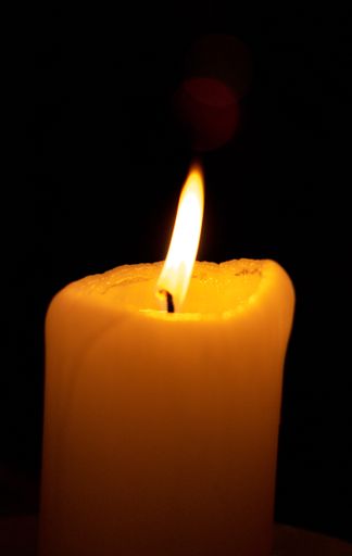 A closeup shot of a burning candle isolated on a black background