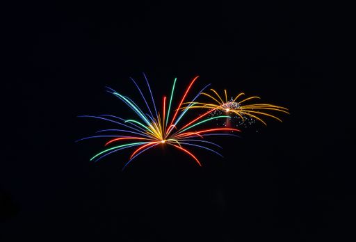 The bright colorful splashes of firework in the dark sky during a national holiday