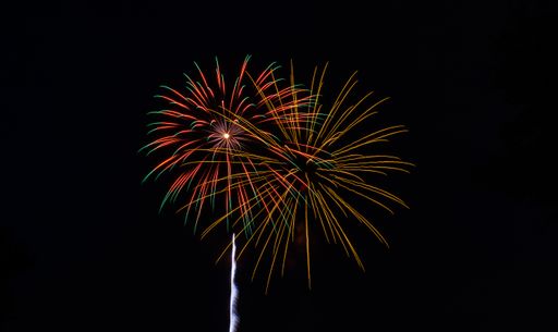 The bright colorful splashes of firework in the dark sky during a national holiday