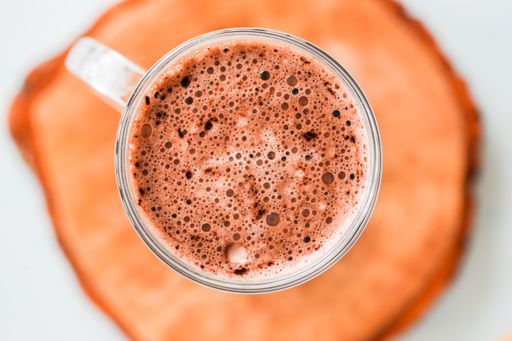 A top view shot of a cup of hot chocolate on a wooden board