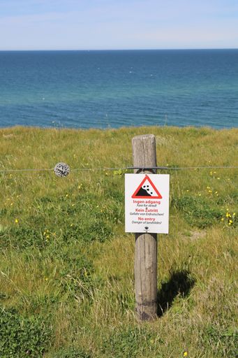 A vertical picture of a no entry sign against an ocean
