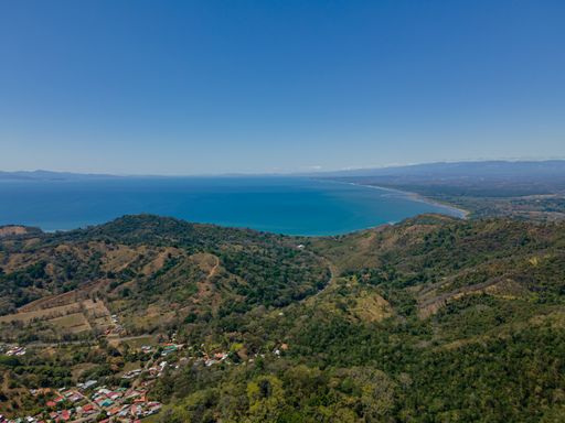 An aerial view of the hills and sea in Costa Rica on a sunny day in summer