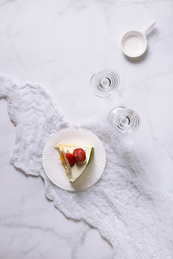 A top view shot of a plate with a strawberry cake, and glasses