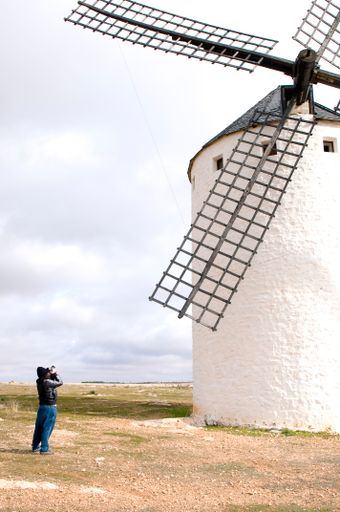 A man taking a photo of a Spanish windmill in Campo de Criptana