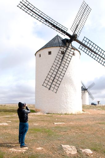 A man taking a photo of a Spanish windmill in Campo de Criptana