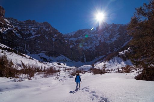 A young girl walking in Winterwanderland (Adelboden), Bern, Switzerland in front of frozen waterfalls