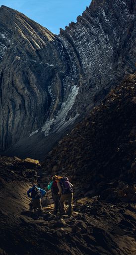 A vertical panoramic shot of people hiking in the mountains