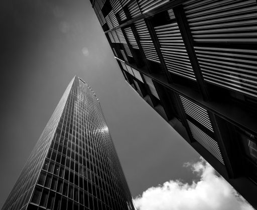 A low angle greyscale shot of tall buildings in Bilbao captured on a sunny day