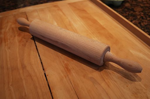 The wooden rolling pin lies on the table.