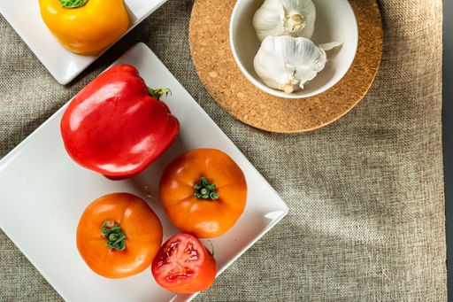 A closeup shot of colorful peppers tomatoes and garlic on the table