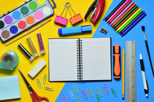 A top view of colorful stationery against blue and yellow background