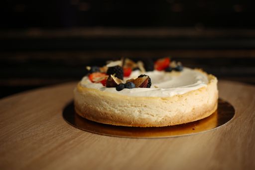 A fresh tasty cake with berries and fruits on a wooden table
