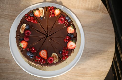 A top view of fresh tasty cake with berries and fruits on a wooden table