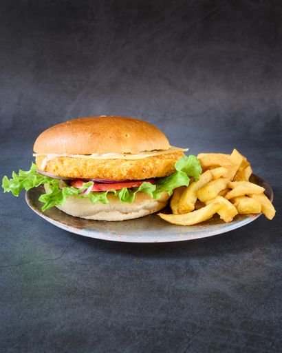 a close up shot of a Chicken burger with french fries on a plate.