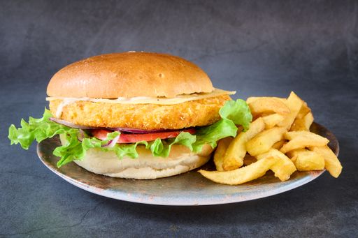 a close up shot of a Chicken burger with french fries on a plate.