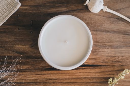 A top view of an aromatic candle on a wooden shelf