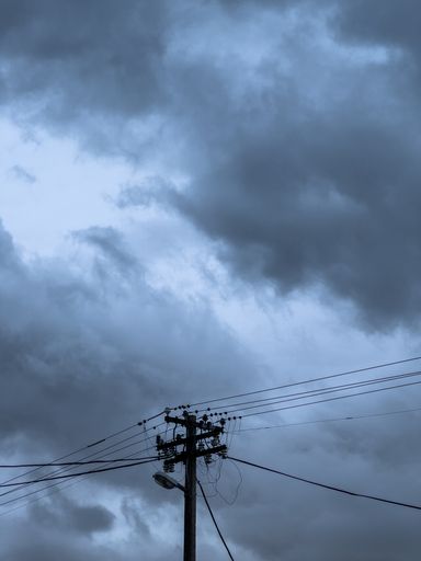 a low angle shot of electro lines agaisnt dark sky