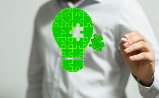 A 3D rendering of a man pointing at a green eco lightbulb puzzle