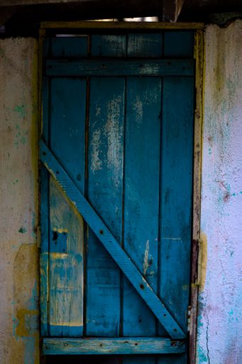 An old building with a wooden blue door in Spanish style