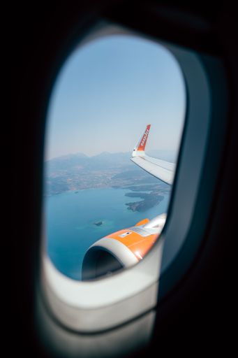 A vertical shot of the plane window looking down onto the Greek island of Meganisi
