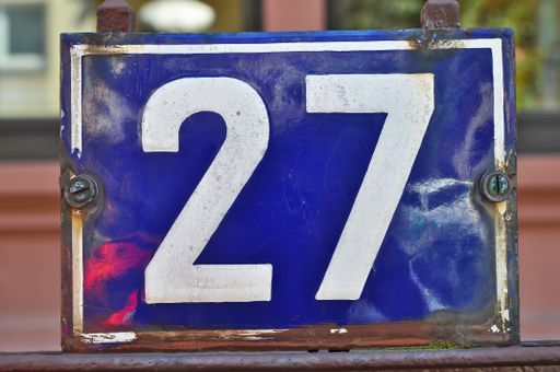 A closeup shot of the number twenty seven sign on a blue background