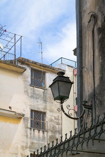 A vertical shot of a vintage lamp on the wall of an old building in Corfu, Greece