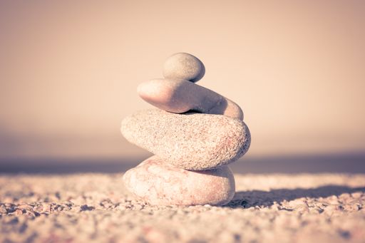 A closeup shot of pebbles stacked on each other with a blurry beige background