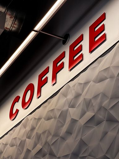 A vertical shot of a red coffee text on the wall