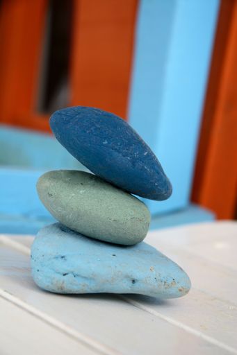 A vertical shot of stacked stones on a wooden table with a blurry background - concept of zen energy
