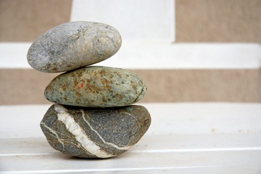 A closeup of stacked stones on a wooden table with a blurry background - concept of zen energy