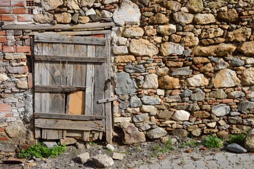 An old stone building with a wooden door under the sunlight at daytime in Turkey