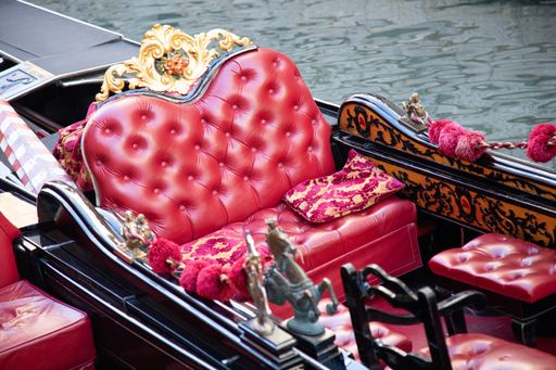A high angle shot of the luxury red seat of a gondola on the river in Venice Italy