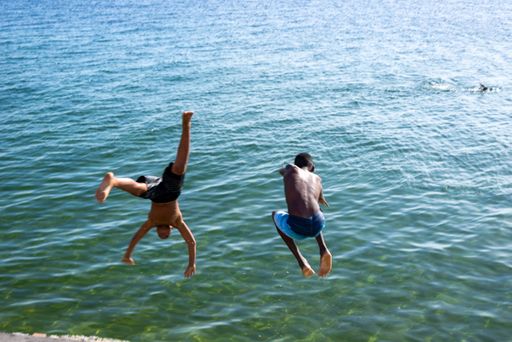 Young jumpers jumping from Boa Viagem beach pier in Salvador city, capital of Bahia, Brazil