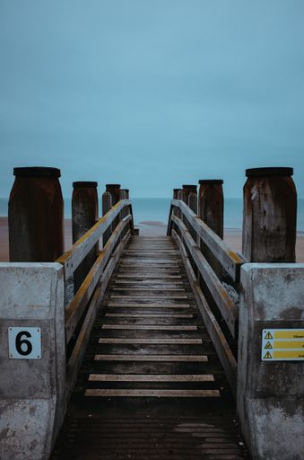 A vertical shot of a pier in Kent, UK on a foggy day