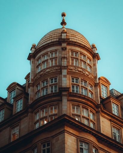 A vertical shot of the facade of an old historic building in London against a cloudless sky