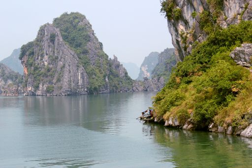 A beautiful shot of limestone islands topped by rainforests in water in Ha Long Bay, Vietnam